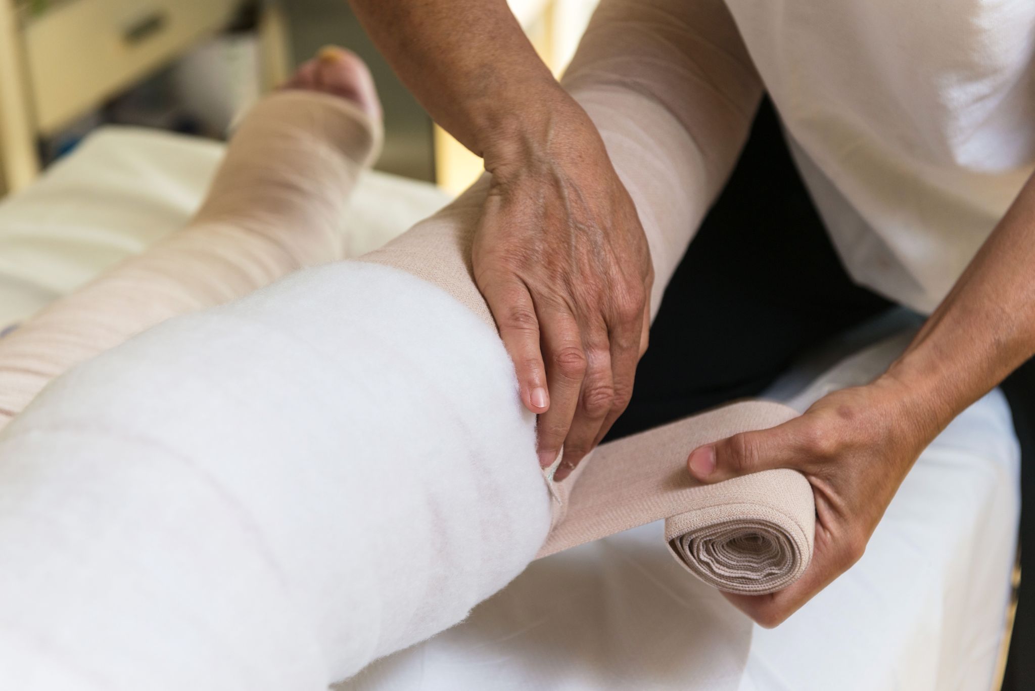 Een been wordt gezwachteld als onderdeel van oedeemtherapie.